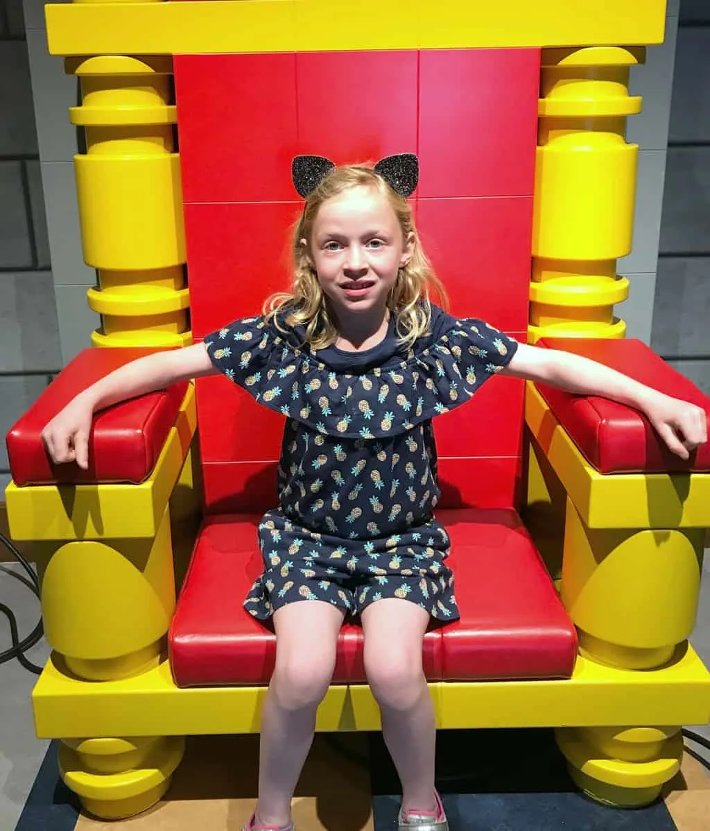 Girl sitting in royal chair inside the LEGOLAND Castle Hotel in California