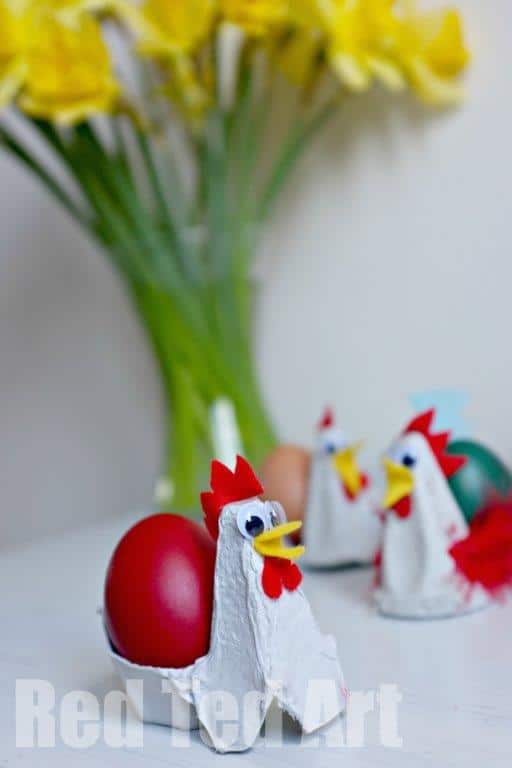 easy chicken craft for preschool made out of a egg carton and red feathers