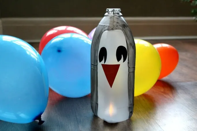 easy penguin kids craft made out of a milk bottle