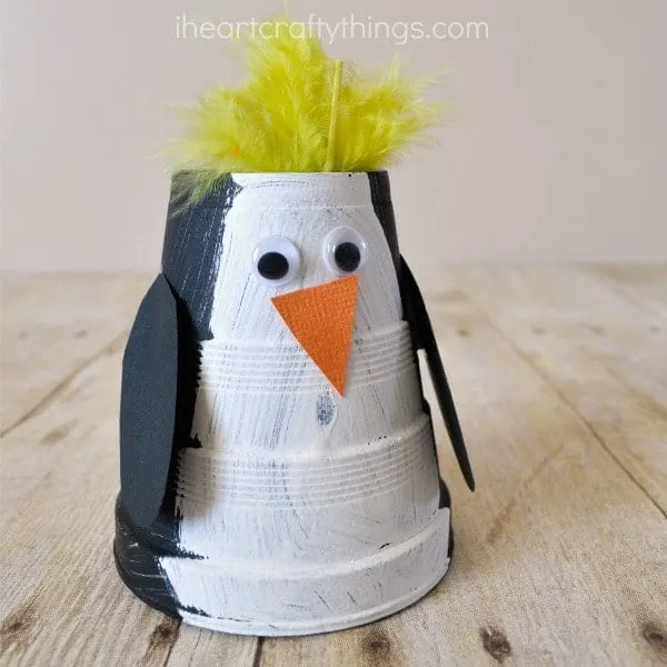 children's penguin craft made out of a paper cup and paint